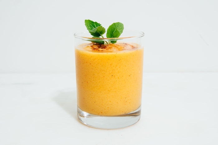 ein glas mit einem oragne getränk mango lassi rezept wie kann man eine mango schneiden minze