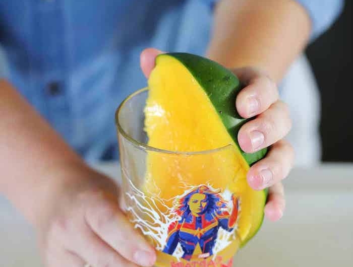 ein glas mit mango mit grüner schale wie kann man eine mango schneiden eine frau