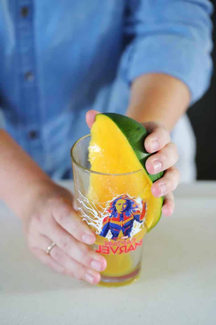 ein glas mit mango mit grüner schale wie kann man eine mango schneiden eine frau