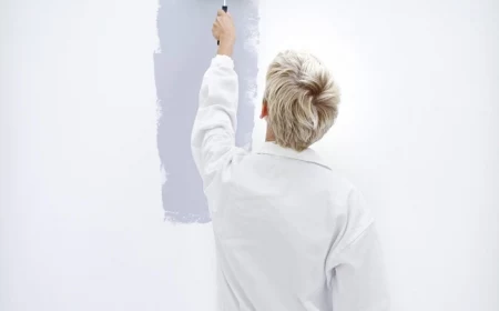 woman painting a wall with a paint roller