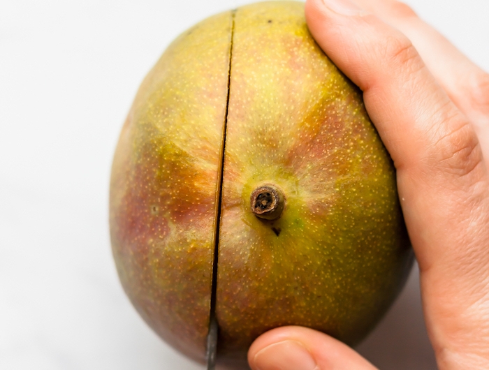 eine hand mit messer schritt wie kann man eine mango schneiden eine reife mango