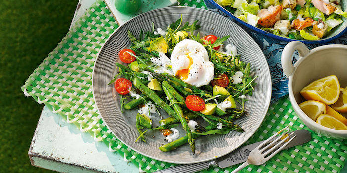 gabel und meser eine kleine weiße schüssel mit zitronen spargel rezepte salat mit grünen spargeln tomaten und eiern