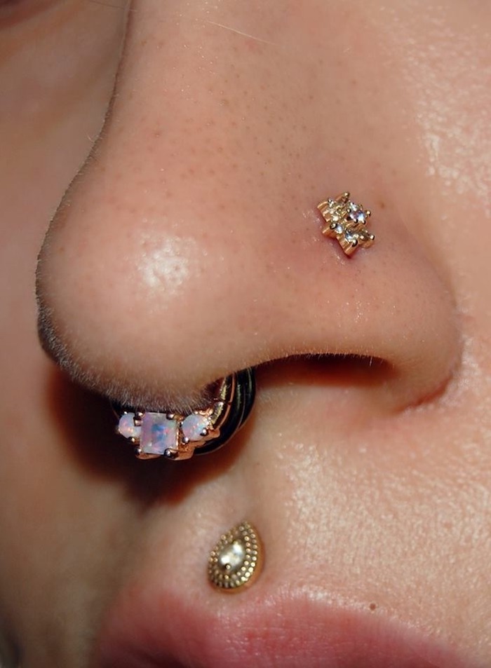 goldener oberlippenpiercing medusa piercing nasenpiercing und nasenring nahaufnahme schöner schmuck für das gesicht
