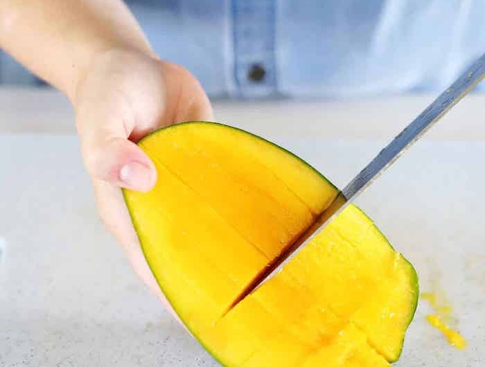 hand mit messer frau mit blauem hemd wie kann man eine mango schneiden diy