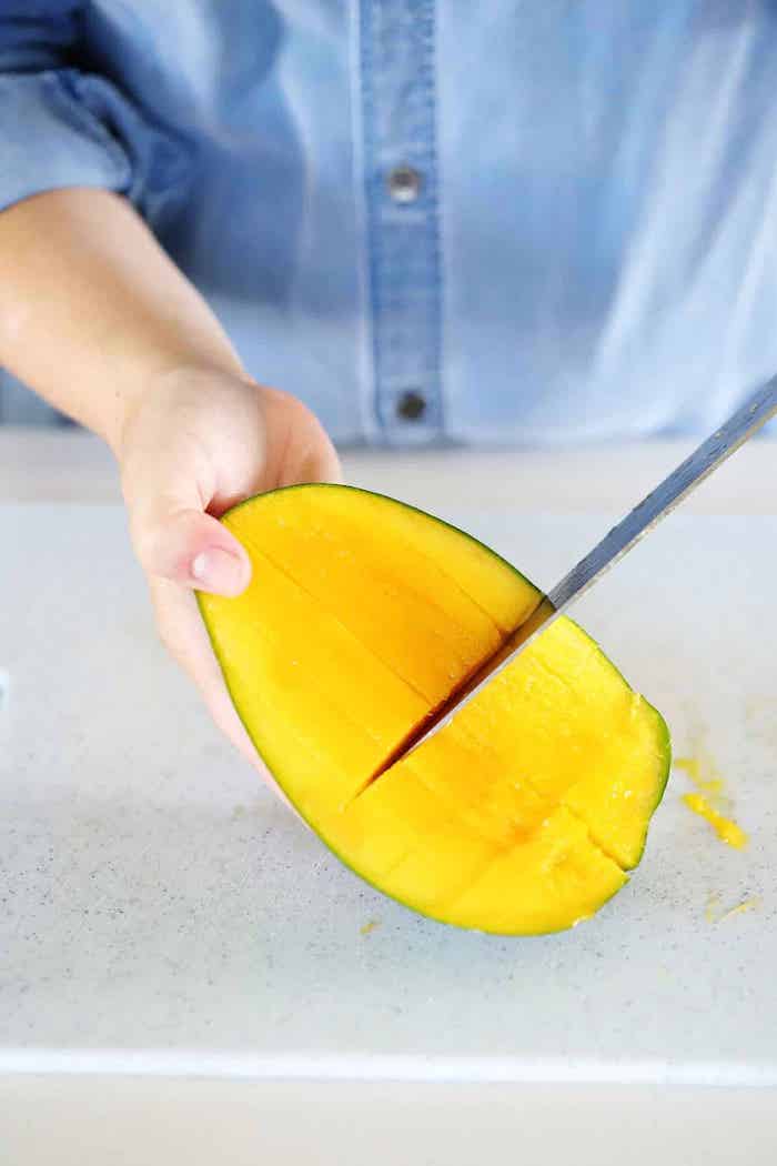 hand mit messer frau mit blauem hemd wie kann man eine mango schneiden diy