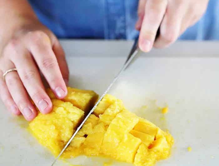 hand mit ring und messer und mango in scheiben eine diy anleitung eine mango schneiden