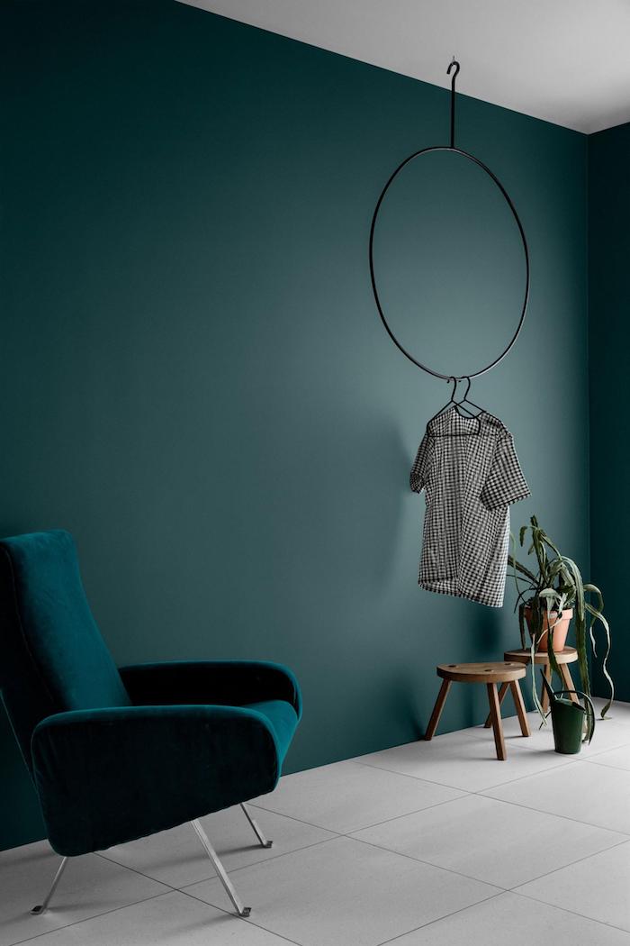 interior design minimalistisch runde tische aus holz kleine grüne pflanze wandfarben trends 2020 petrol grün trends moderner sessel in blaugrün