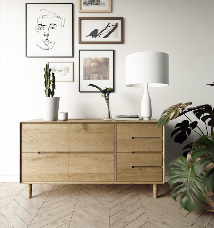 lowboard skandinavisch aus holz dekoration grüne pflanze weiße lampe linienzeichnung und moderne bilder deko scandi style wohnzimmer