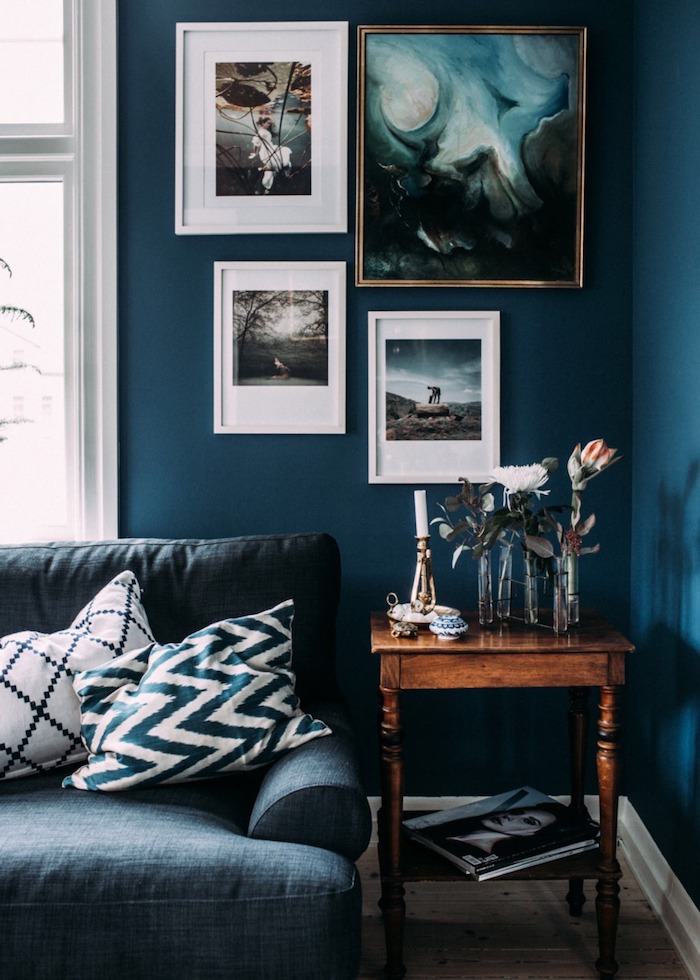 moderne inneneinrichtung wohnzimmer blaue wandfarbe schöne gemälde kleiner kaffeetisch aus holz blauer couch