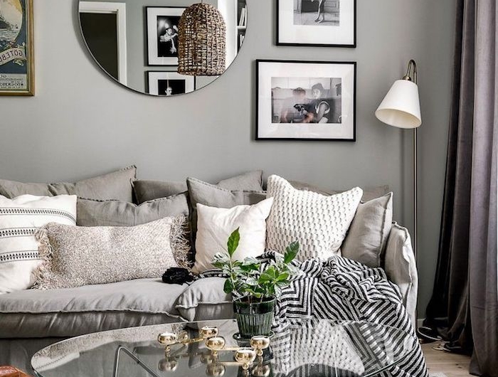 runder spiegel skandinavisches wohnzimmer gemütlich einrichten kaffeetisch aus glas mit schwarzen beinen skandi teppich fotos an der wand