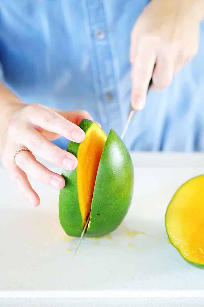 schritt für schritt anleitung wie kann man eine mango schneiden eine frau mit messer und mango
