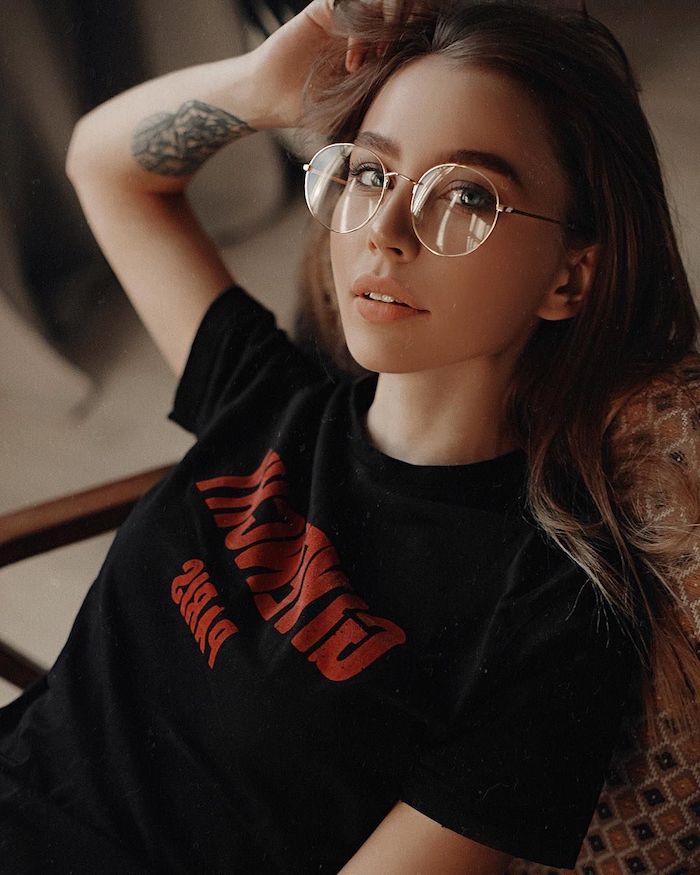 schwarzes t shirt mit rotem print junge dame mit einem tattoo auf der hand trends 2020 runde brille damen casual style inspiration