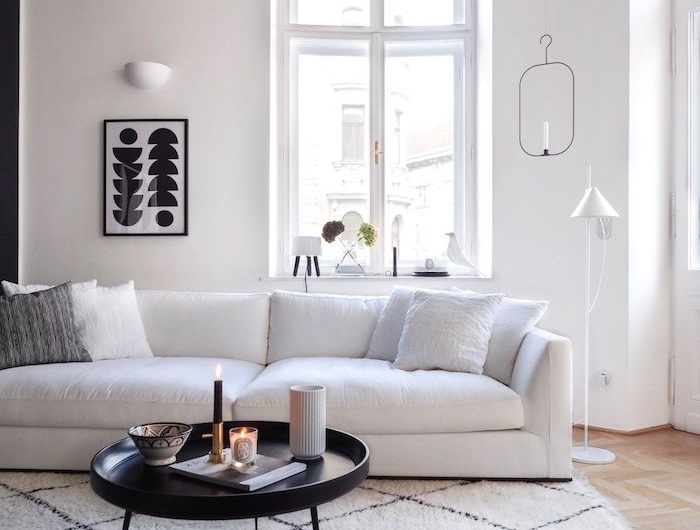 skandinavischer teppich unter weißem sofa und schwarzem couchtisch mit drei beinen schwarz weißes bild dekoration ideen deko skandinavisch