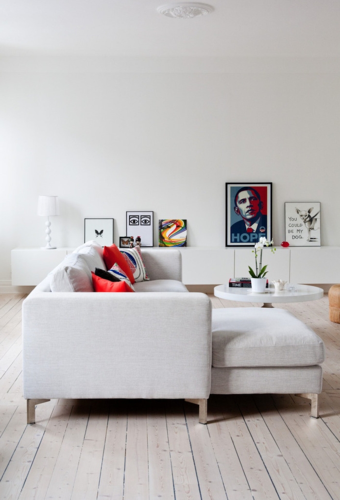skandinavisches design mit zeitgenössischem chic ekcosofa in grau mit roten kissen bilder als dekoration runder kaffeetisch scandi sofa