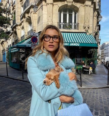 street style paris frau im eleganten hellblauen mantel lange blonde haare kleiner hund moderne brillen dicke brillengestelle damen