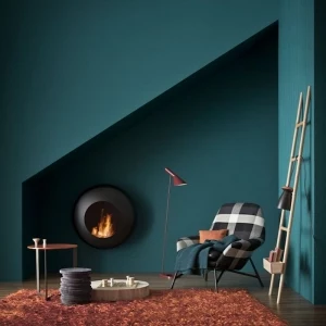 stylisches wohnzimmer einrichten ideen petrol wandfarbe grün blau flauschiger teppich braun schwarz weißer sessel runder tisch