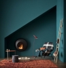 stylisches wohnzimmer einrichten ideen petrol wandfarbe grün blau flauschiger teppich braun schwarz weißer sessel runder tisch