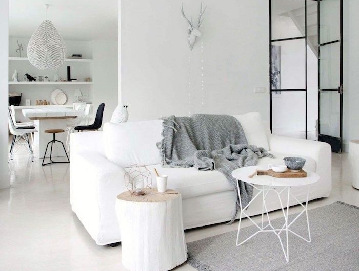 wohnzimmer skandinavisch einrichten weißes sofa grauer skandi teppich inneneinrichtung in neutralen farben runder kaffeetisch minimalistische gestaltung wohnung