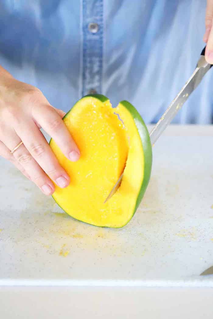 zwei hände und ein scharfer messer eine hand mit ring eine reife mango