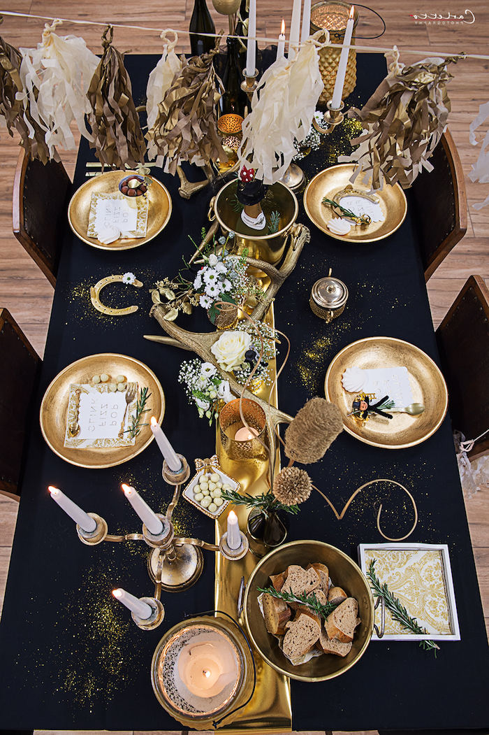 deko zur goldenen hochzeit in gold und schwarz teller in gold weiße kerzen schwarze tischdecke