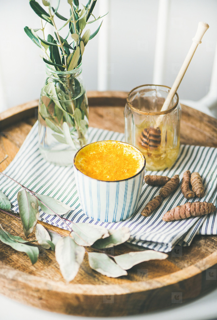 die zutaten für eine vegane goldene milch rezept. eine tasse mit goldener milch zimt und honig