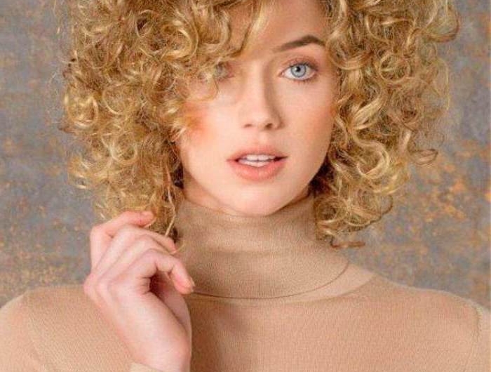 frisur für mittellangen haare blond frau mit blauen augen und beigem rollkragenpulli