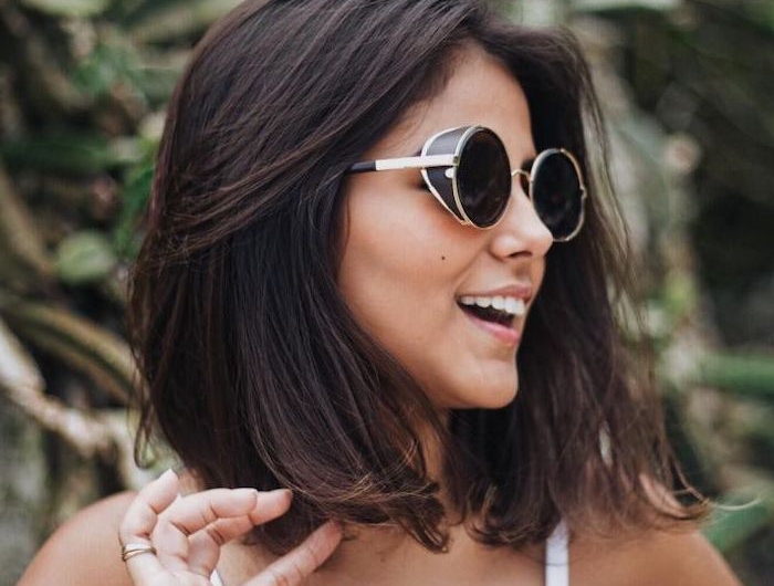 frisur für schulterlangem haarnschnitt glatt frau mit weißem top und schwarzen sonnenbrillen