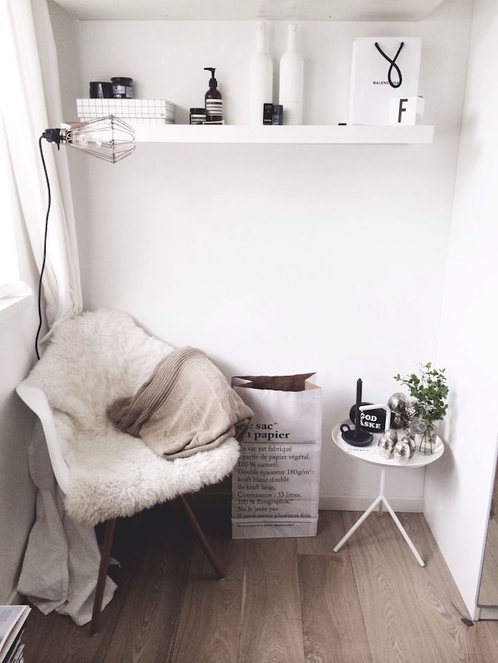 minimalistische inneneinrichtung weiß dekoartikel wohnzimmer offene regale stuhl mit flauschiger decke kleiner runder tisch industrial chic lampe