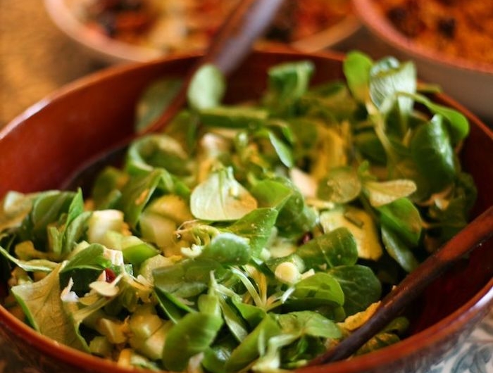 rote schüssel mit salat mit grünne blättern eines feldsalats löffel tisch dressing für feldsalat