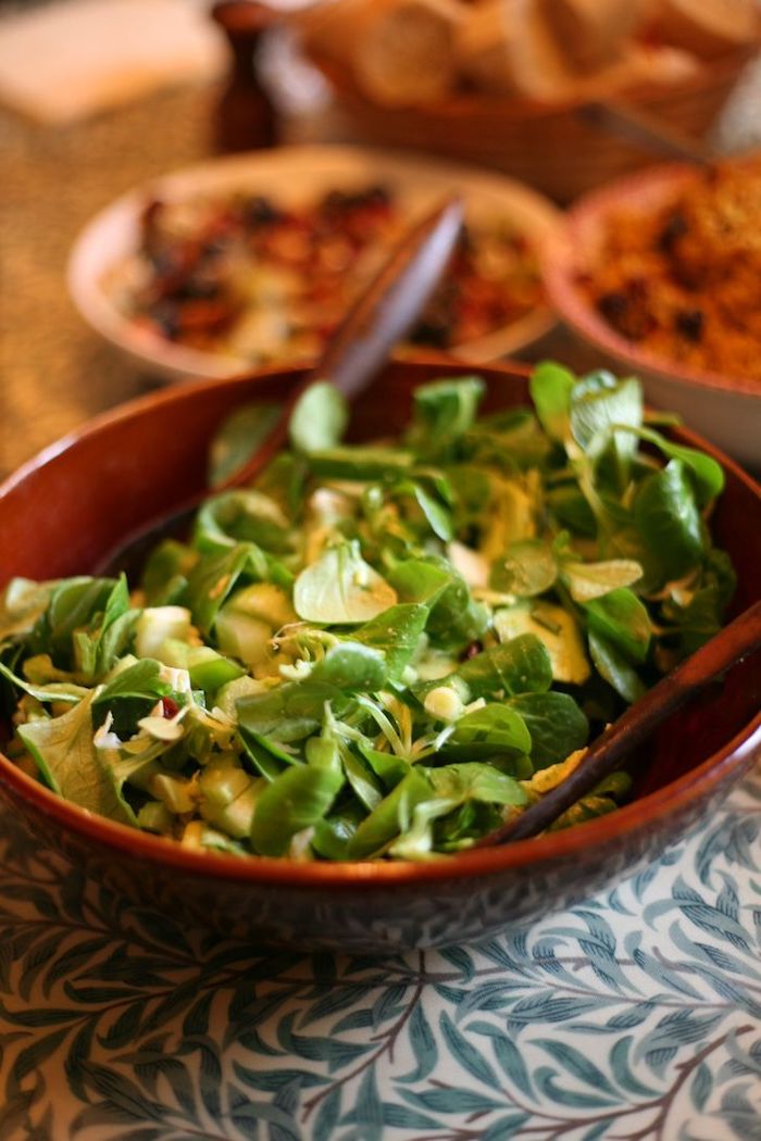 rote schüssel mit salat mit grünne blättern eines feldsalats löffel tisch dressing für feldsalat