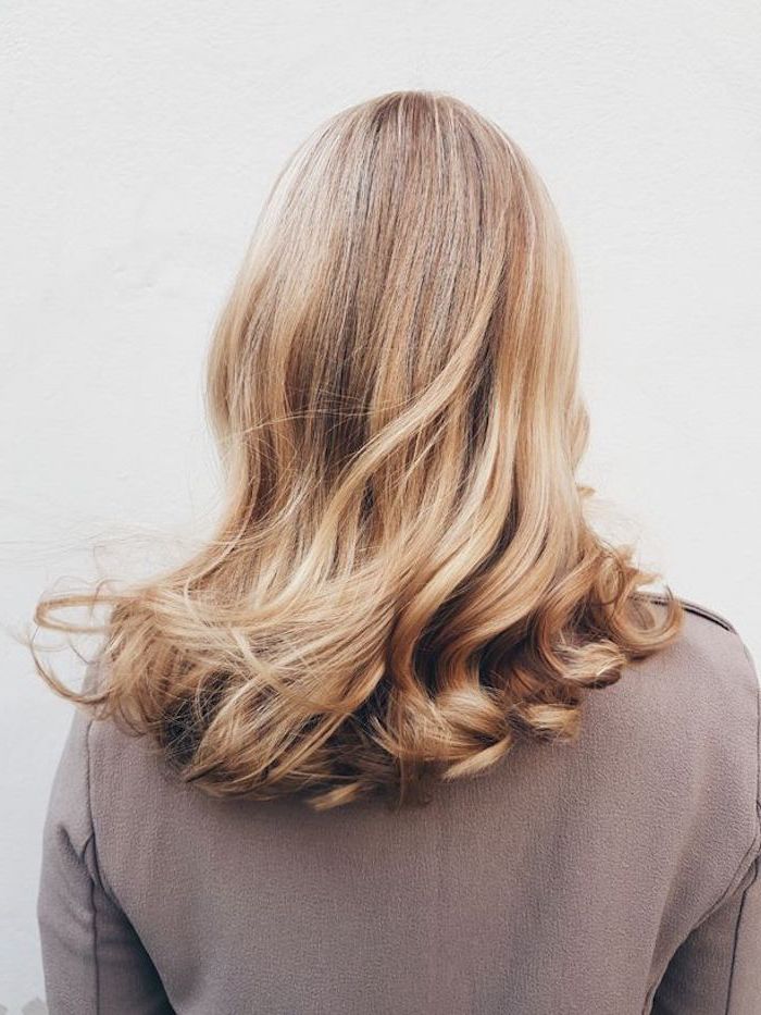 schöne frisuren für schulterlange haare blondes haar frau mit hellbraunem pulli auf weißem hintergrund