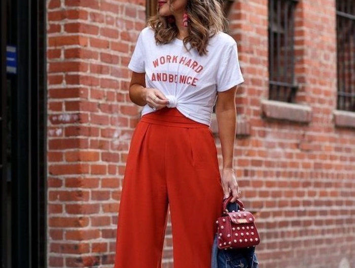 stylisches outfit rote collot hose in rot weißes t shirt mit print kurzhaarfrisuren braune haare mit blonden strähne weiße sonnenbrillen jeansjacke schuhe mit absatz und weite hose