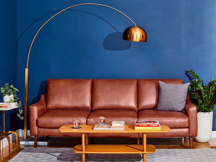wohnzimmerwand ideen wand in marineblau mit sofa aus leder kombinieren lampe kupferfarbig