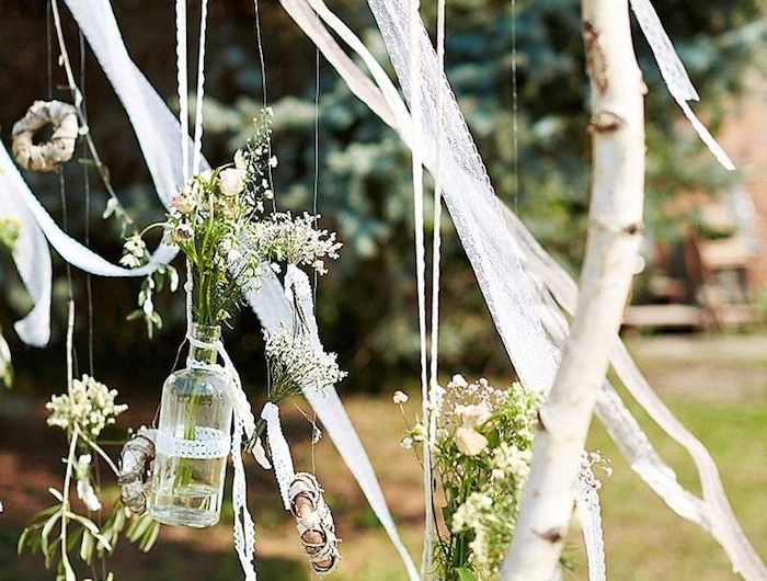 besondere anlässe dekoration boho stil hochzeit aufgehängte kleine flaschen mit blumen auf bierkenstamm originelle birkenholz deko