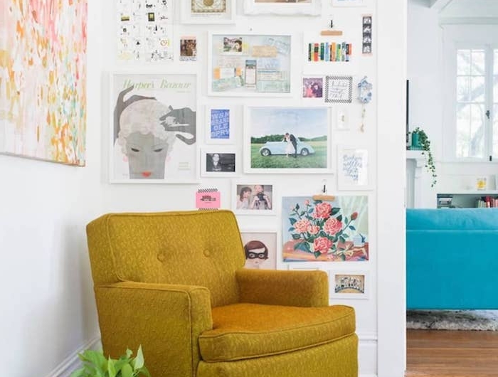 bilderwand gestalten kleine und große zeichnungen blauer teppich senffarbener sessel wohnzimmerwand ideen abstraktes buntes gemälde