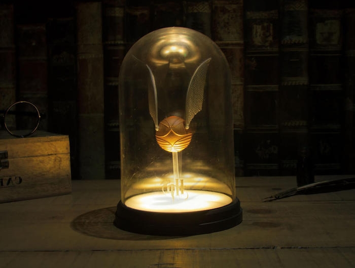 eine lampe mit einem kleinen goldenen snitch harry potter lamoe für das schlafzimmer