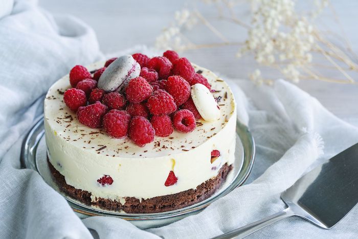 eine torte mit sahne und roten kleinen himbeeren dekoration für torten schneller kuchen mit wenig zutaten