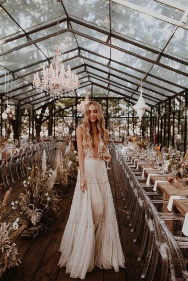eleganter stil lange gewellte haare ausgefallene brautkleid tiefer v ausschnitt kleid mit hoher taille romantischer look hochzeit boho chic