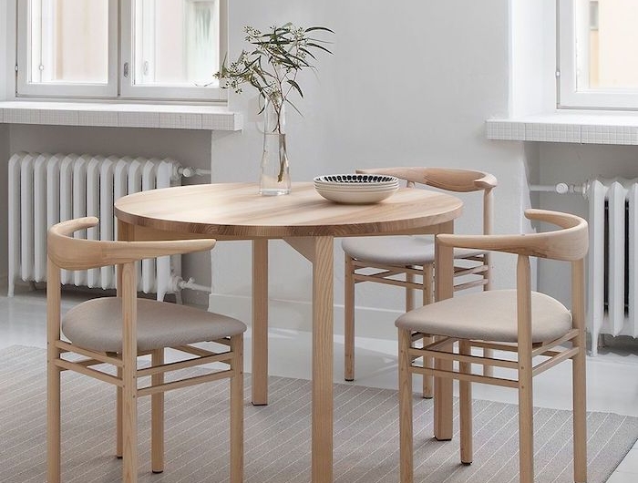 esszimmer einrichten ideen runder vierbeiniger tisch aus holz scandi style möbel interior design minimalistisch drei essstühle beiger teppich schale auf dem tisch