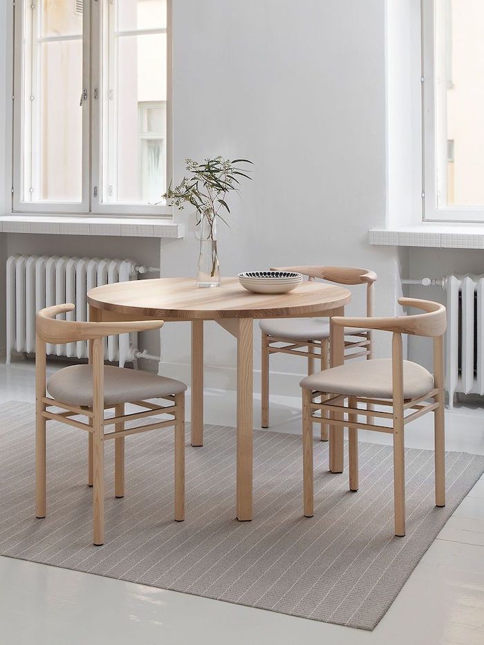 esszimmer einrichten ideen runder vierbeiniger tisch aus holz scandi style möbel interior design minimalistisch drei essstühle beiger teppich schale auf dem tisch
