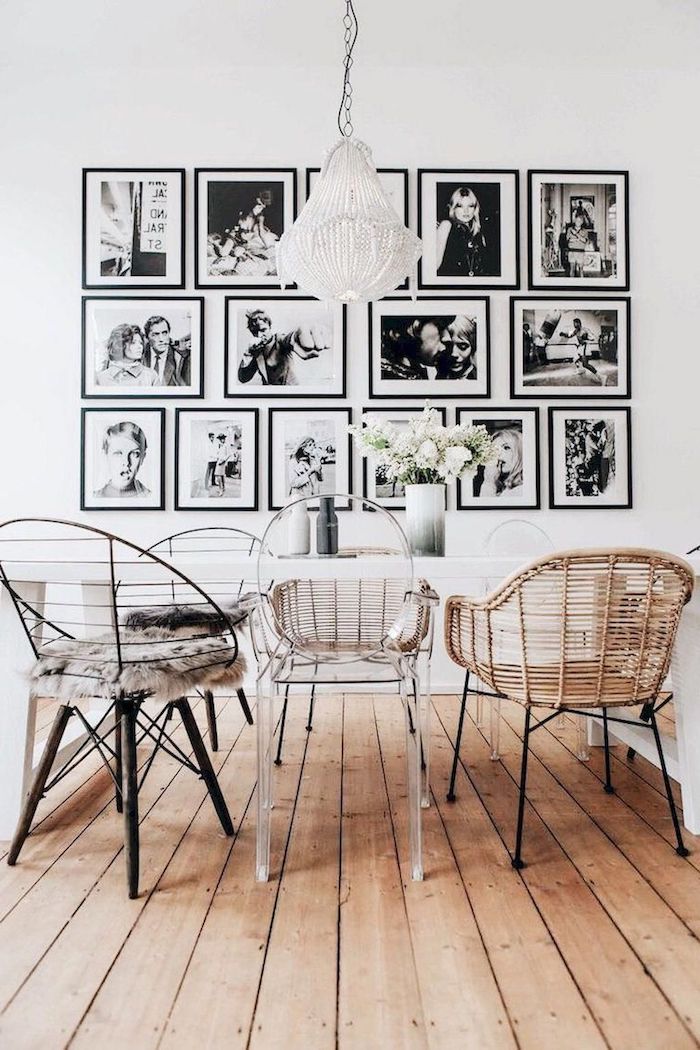 fotowand mit schwarz weißen fotos dekoartikel wohnzimmer essbereich weißer tisch verschiedene stühle hängende lampe vase mit weißen blumen