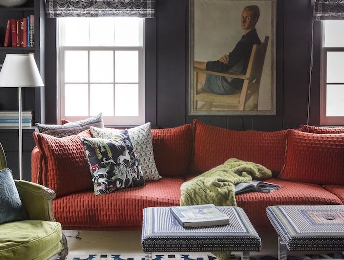 großes couch rot weiß blau schwarzer teppich wohzimmer ideen modern bunte kissen großes gremälde von einem mann schwarze jalousien