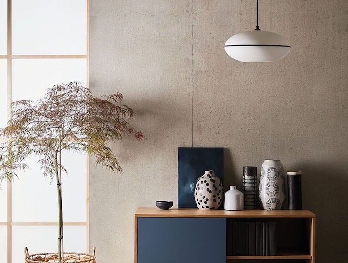 holzkomode dunkelblaue türe japandi inneneinrichtung skandinavische deko wohnzimmer korb topf dekoratover baum vasen verschiedene muster