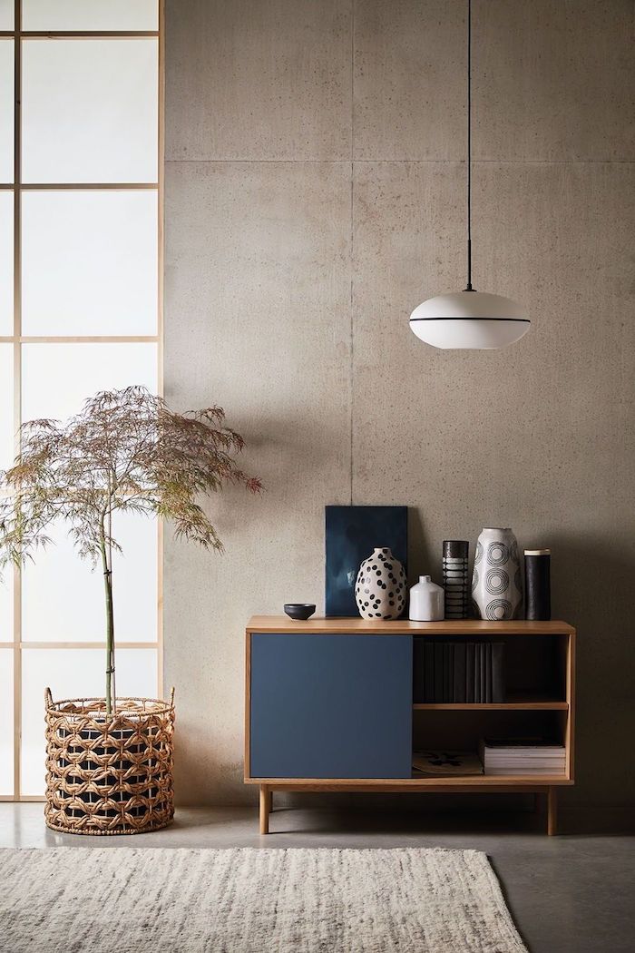 holzkomode dunkelblaue türe japandi inneneinrichtung skandinavische deko wohnzimmer korb topf dekoratover baum vasen verschiedene muster