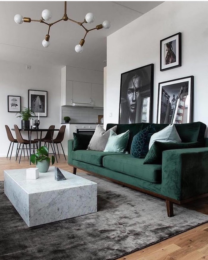 interior design inspiration 2020 große schwarz weiße fotos an die wand stilvoller grüner couch weißer kaffeetisch aus marmor wohnzimmer einrichten modern grauer teppich