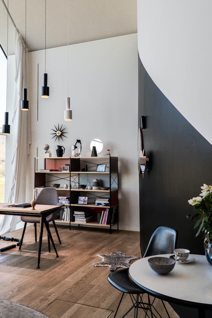 interior design inspiration moderne inneneinrichtung holzboden minimalistische dekoartikel wohnzimmer schwarze weiße hängende lampem und wand runder tisch 