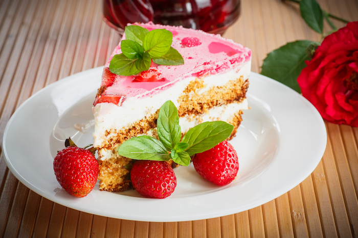 kuchen schnell und einfach weißer teller mit einem kuchen mit guark und roten erdbeeren eine groé rote rose kuchen rezepte einfach und schnell mit wenig zutaten