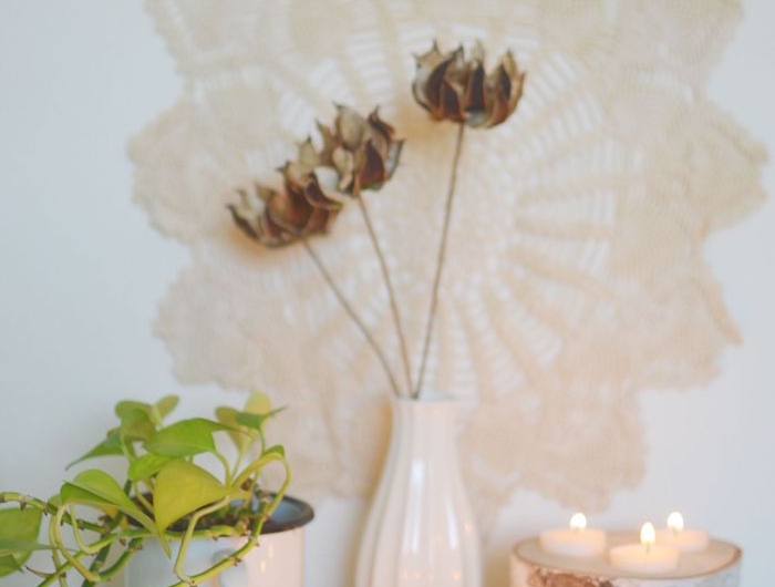 makramee wanddeko blumenmuster weiße vase blumen holzstamm deko holzscheiben kerzenhalter teelichter dekoration wohnzimmer inspo