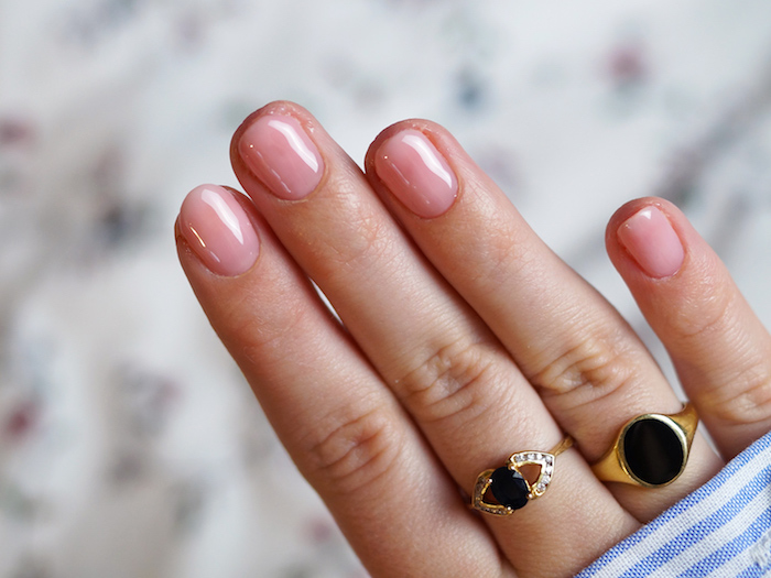 minimalistische goldene ringe mit schwarzen steinen sehr kurze nägel rosa nagellack nageldesign babyboomer blau weißes hemd