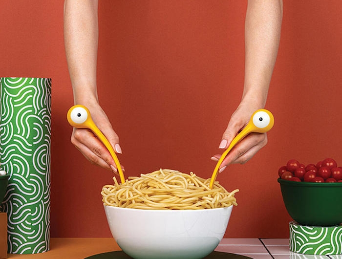 monster pasta eine weiße schüssel mit spaghetti und gelben löffel und gabel mit augen